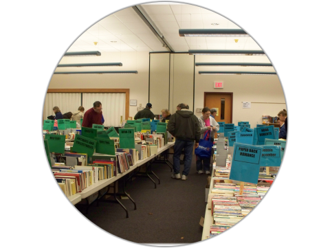 People looking through books on tables at the Baldwinsville Library Book Sale